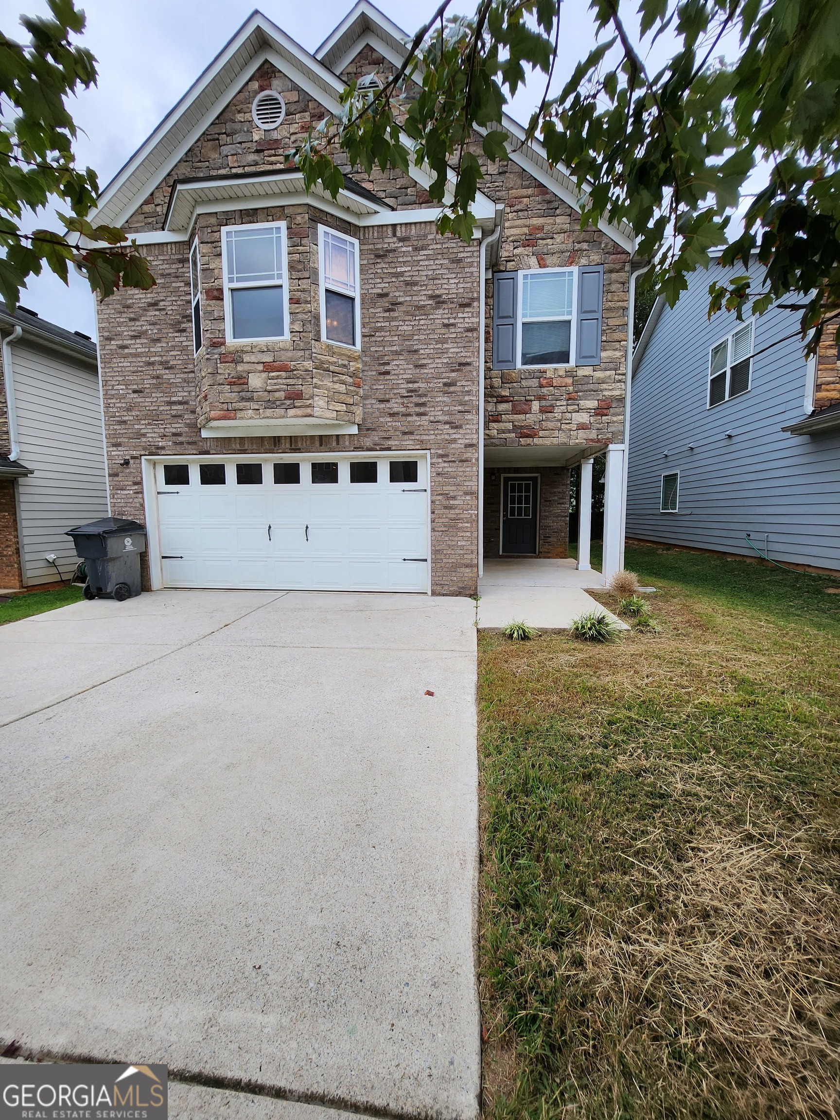 a front view of a house with a garden and yard