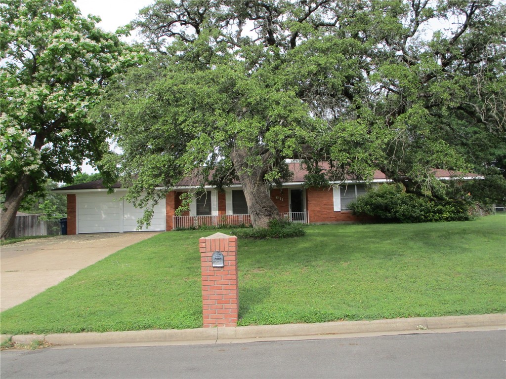 a front view of a house with a garden and yard