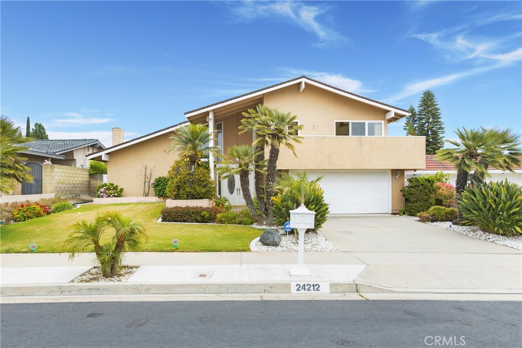 a front view of a house with a yard and potted plants