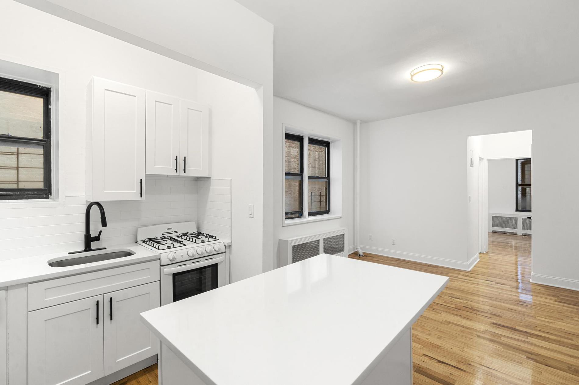 a kitchen with a sink a stove and cabinets