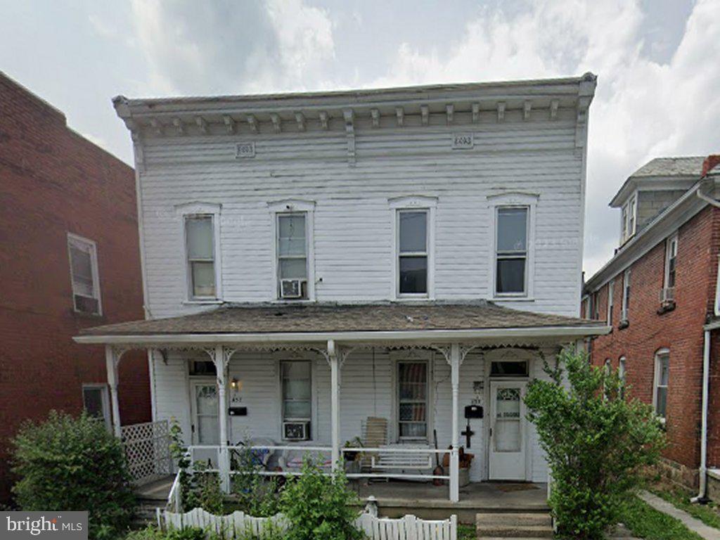 a front view of a house with plants