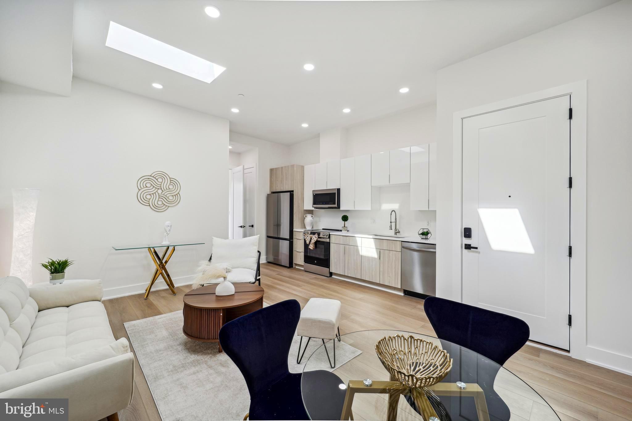 a living room with furniture kitchen view and a refrigerator