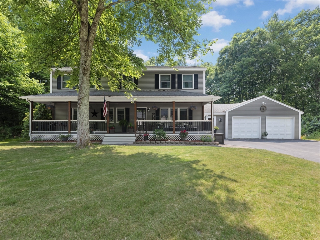 a front view of house with yard and trees in the background