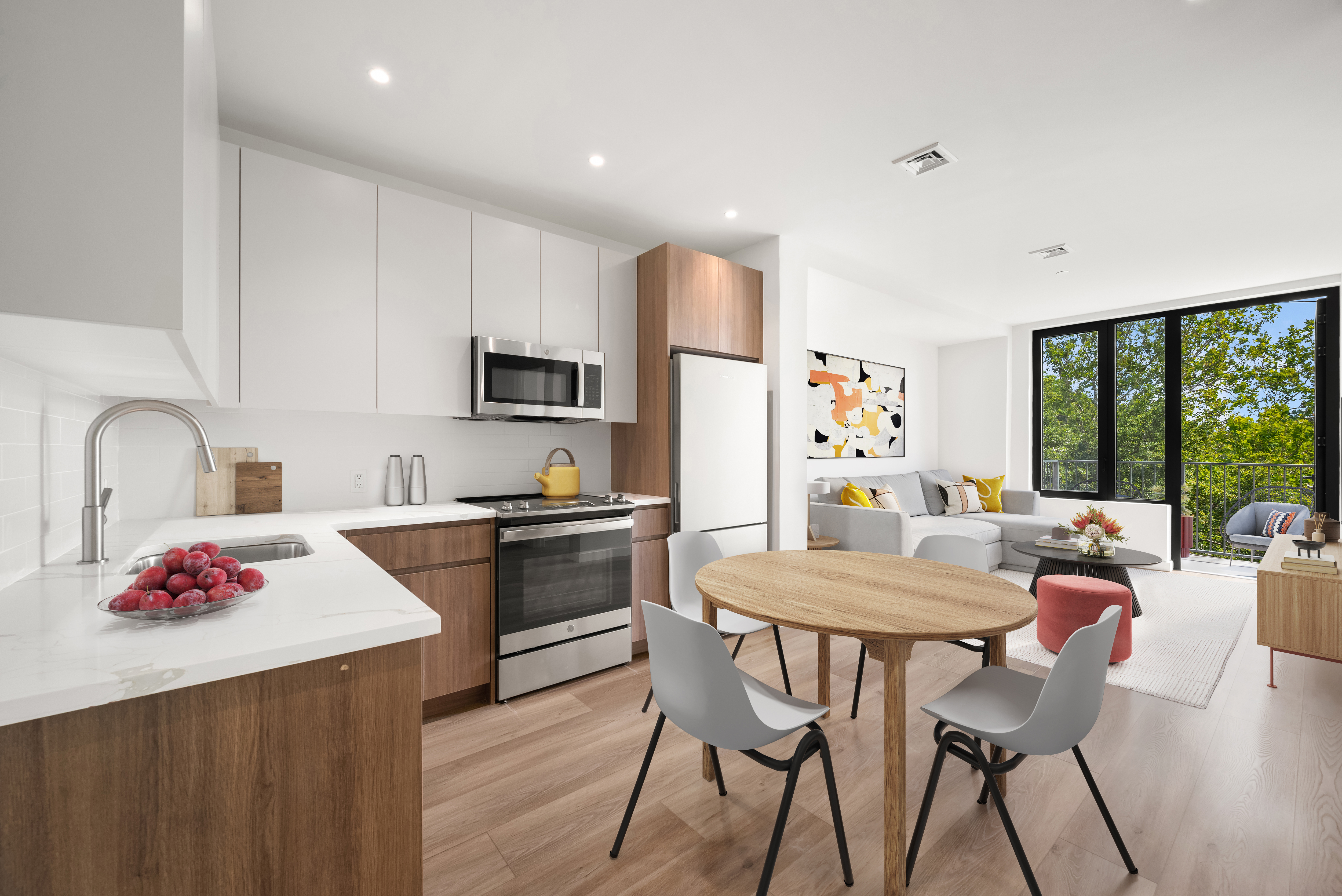 a kitchen with granite countertop a dining table chairs refrigerator and sink