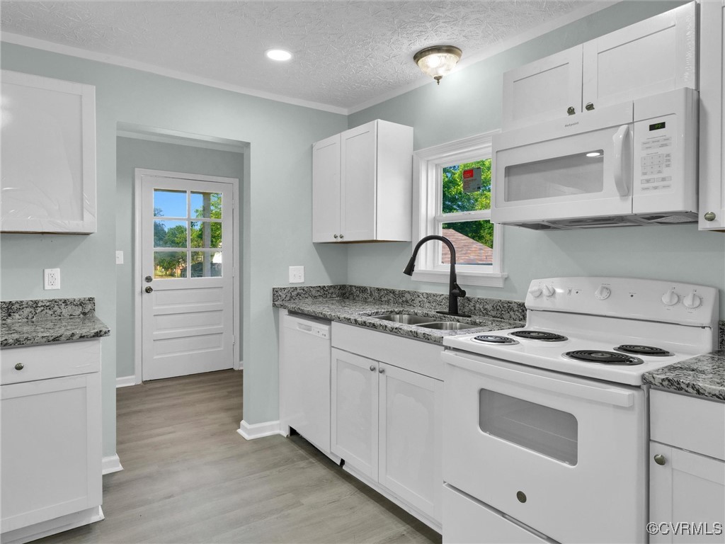 a kitchen with granite countertop a stove sink and cabinets