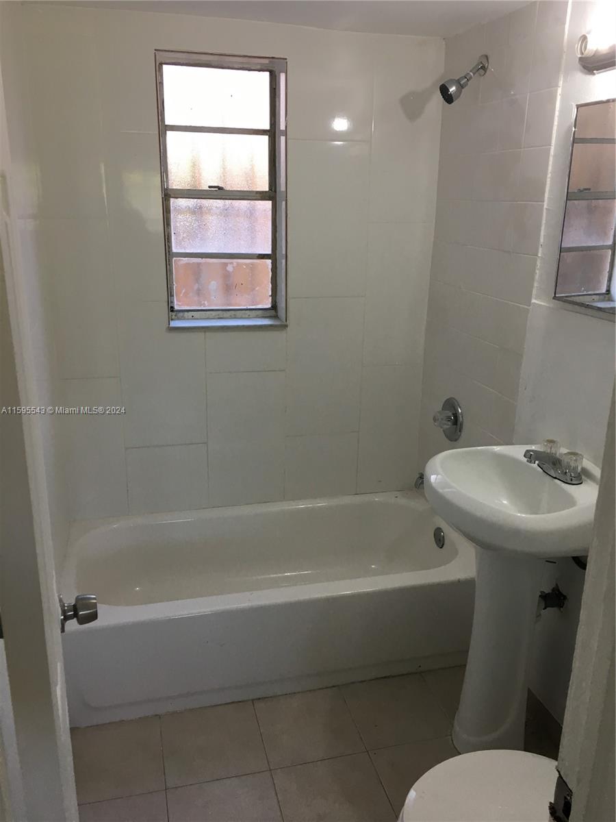 a white bath tub sitting next to a white toilet and a sink