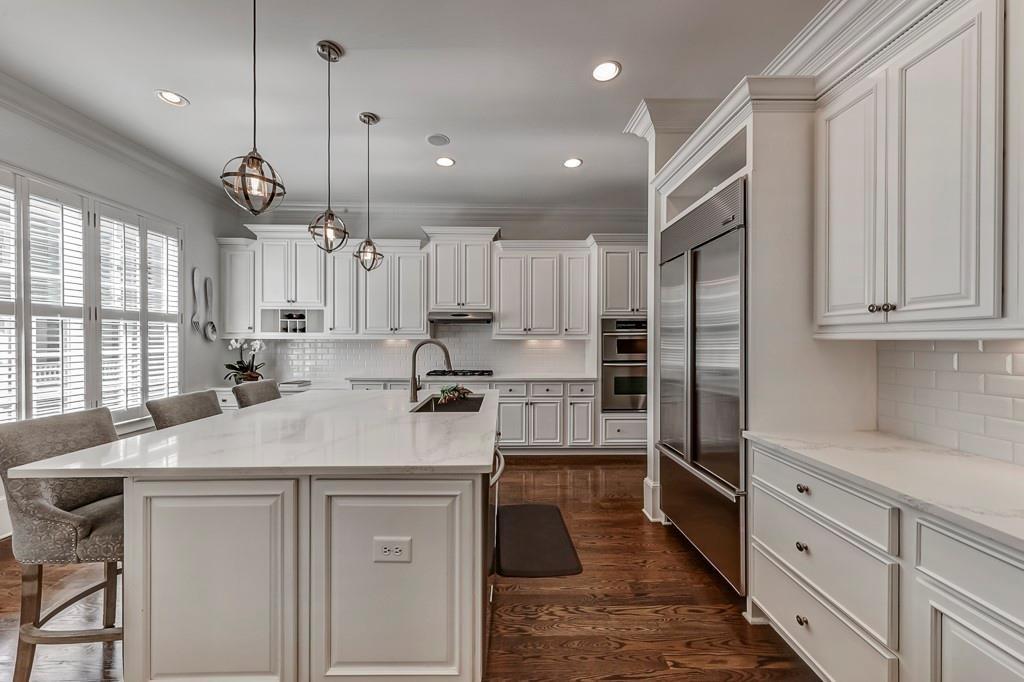 a kitchen with kitchen island a sink stainless steel appliances and cabinets