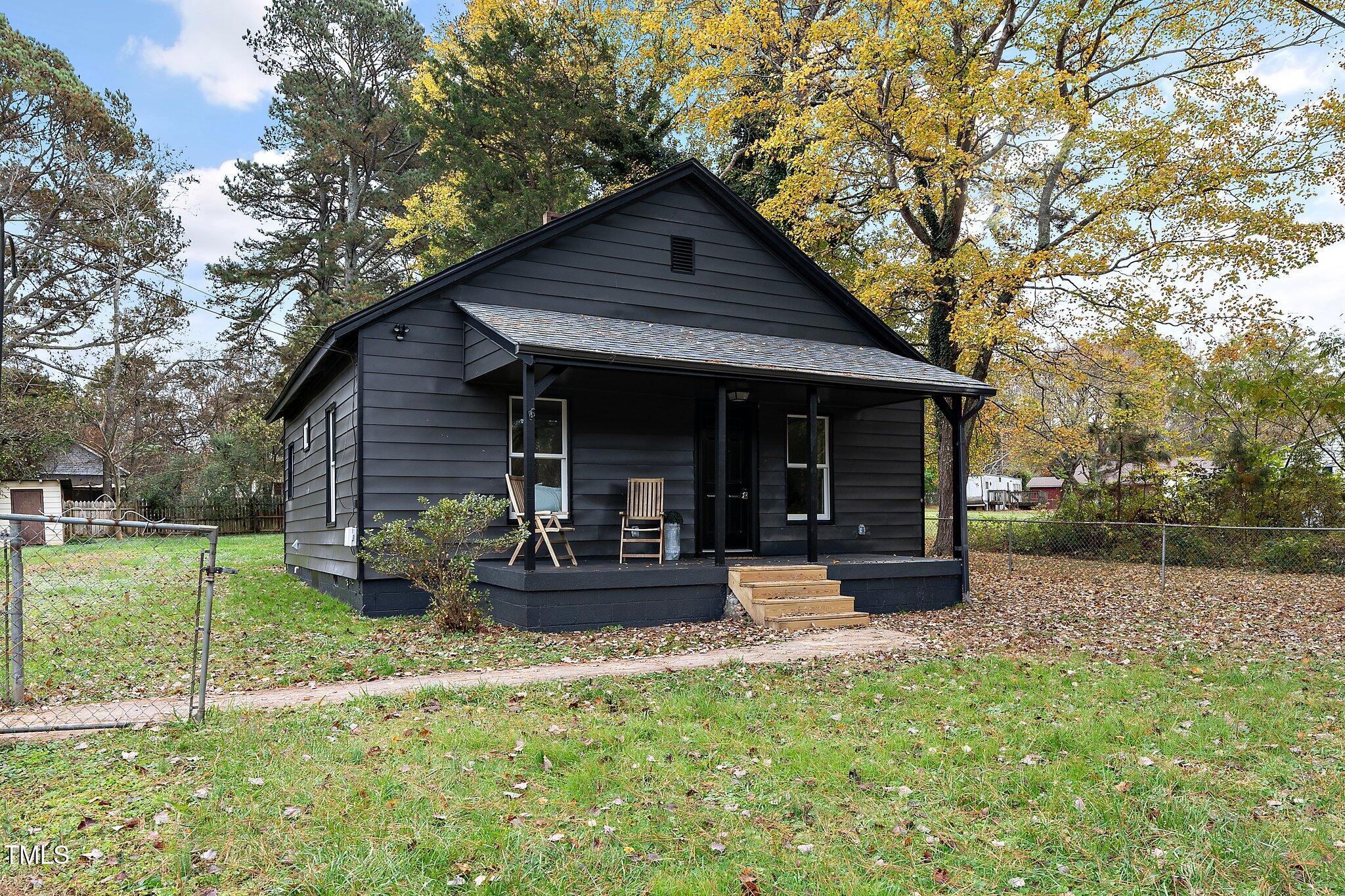 a front view of a house with a yard and trees