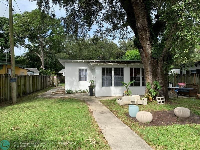 a view of a house with backyard and sitting area