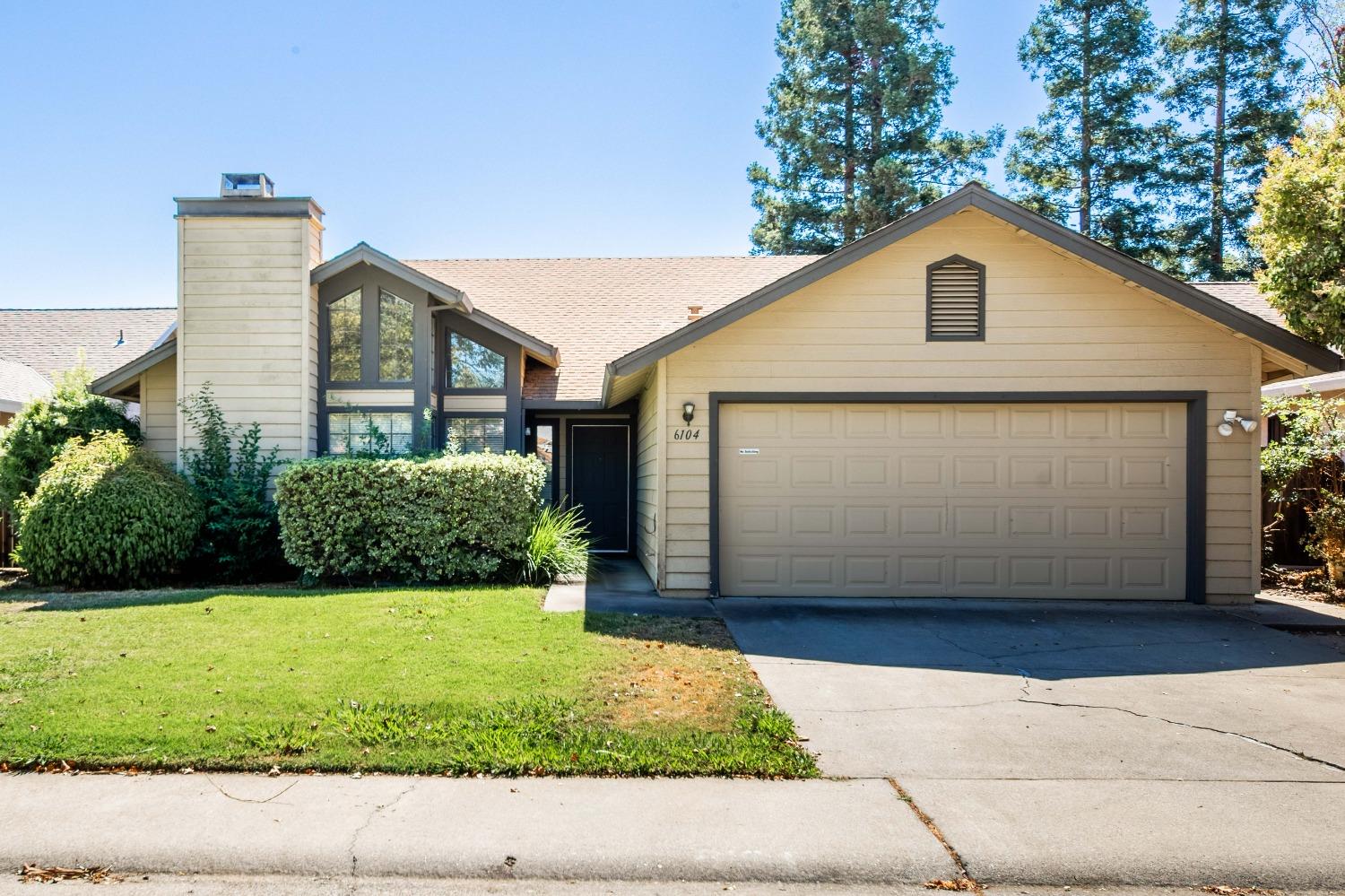 a view of a house with garage and yard