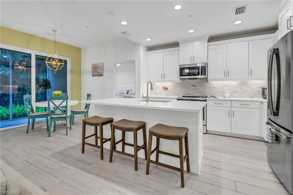 Kitchen with white cabinetry, a kitchen island with sink, and stainless steel appliances