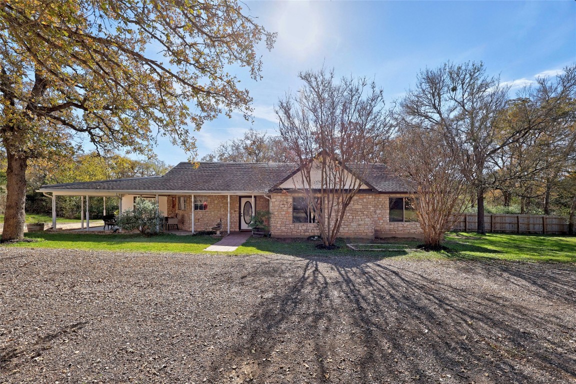 a front view of a house with a yard and trees