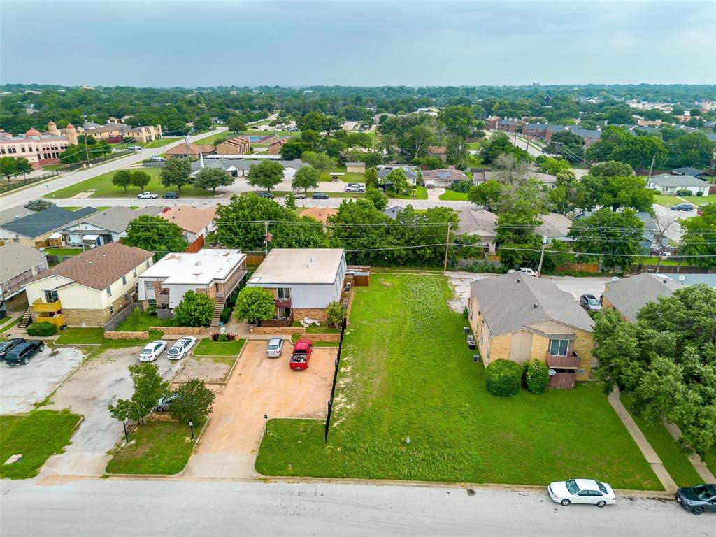 an aerial view of residential houses with outdoor space and parking