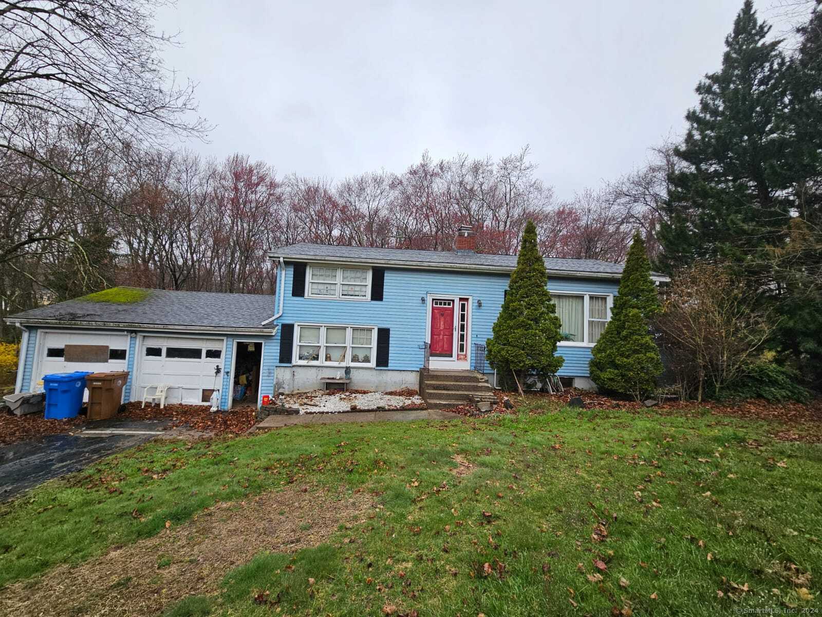 a front view of a house with a garden and trees