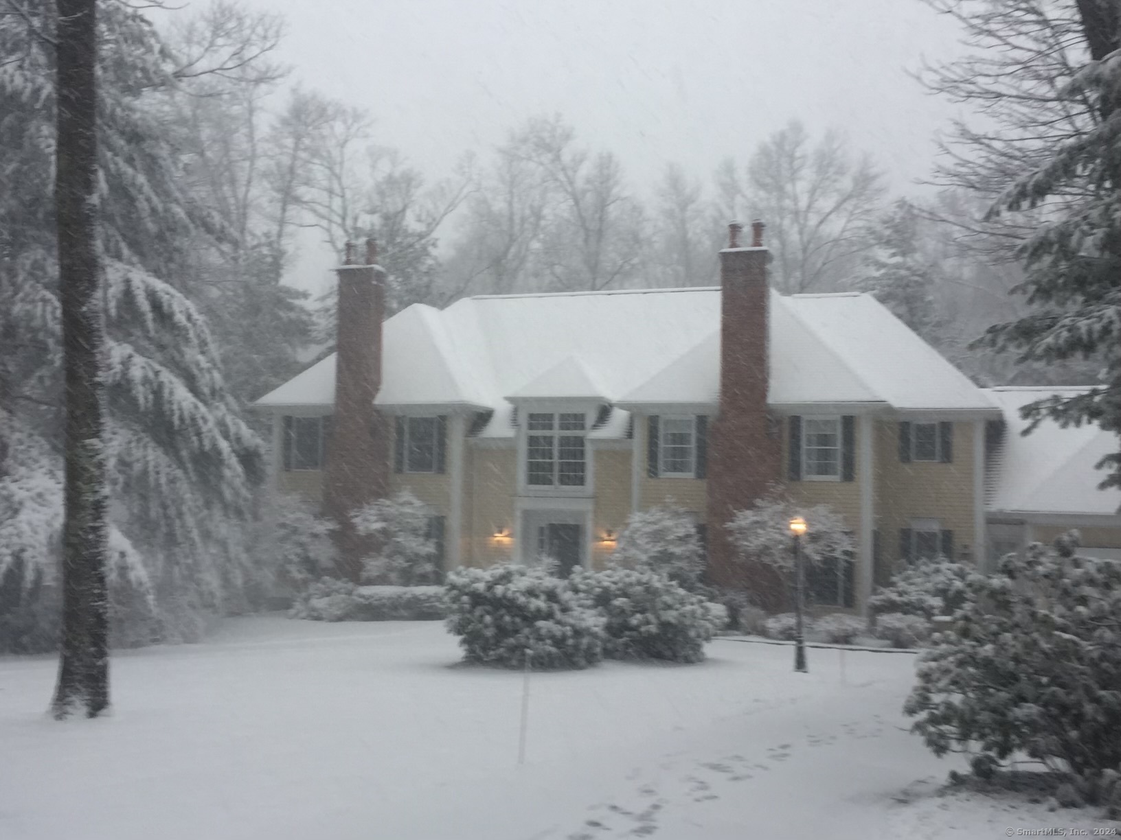 a view of a house with a yard and covered with snow