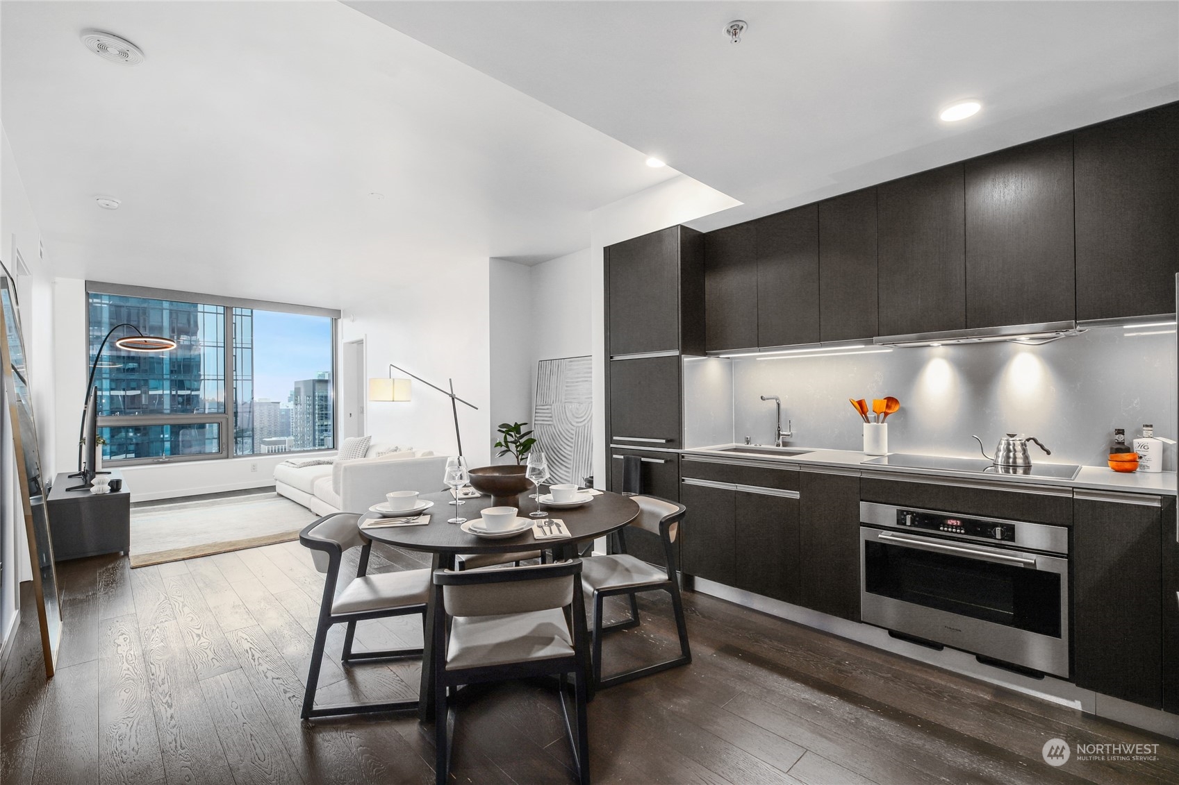 a kitchen with stainless steel appliances wooden floor dining table and chairs