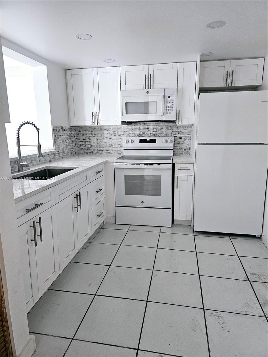 a kitchen with cabinets stainless steel appliances and a sink