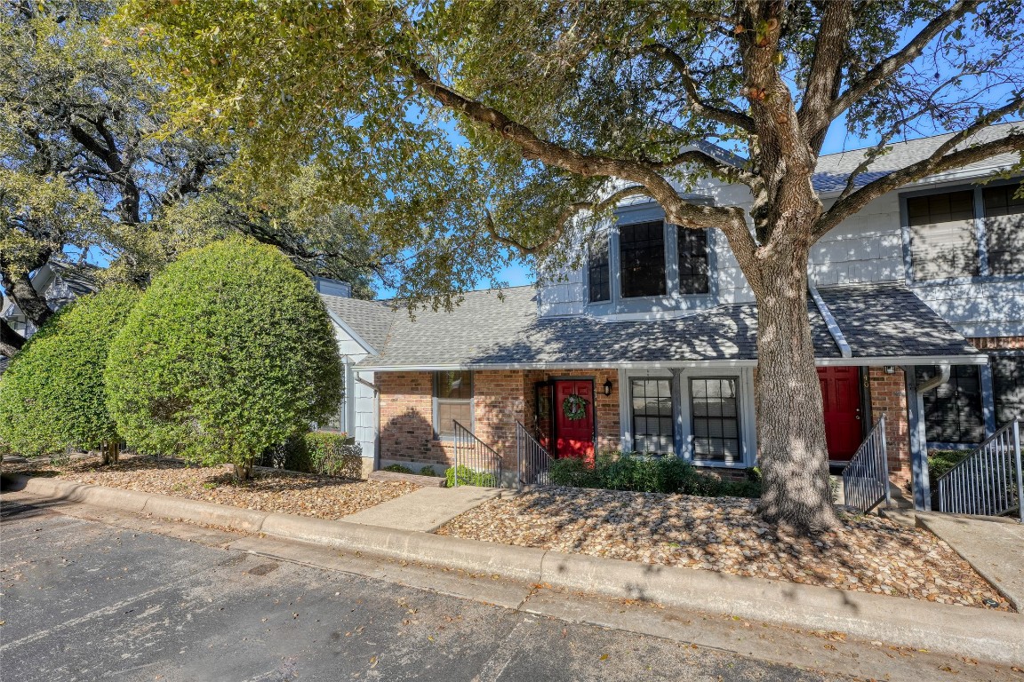 a front view of a house with a tree