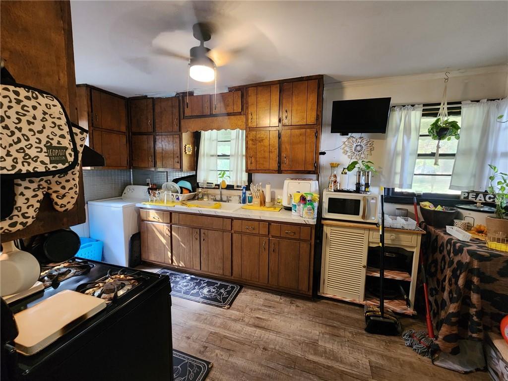 a kitchen with a stove a refrigerator and a dining table with wooden floor