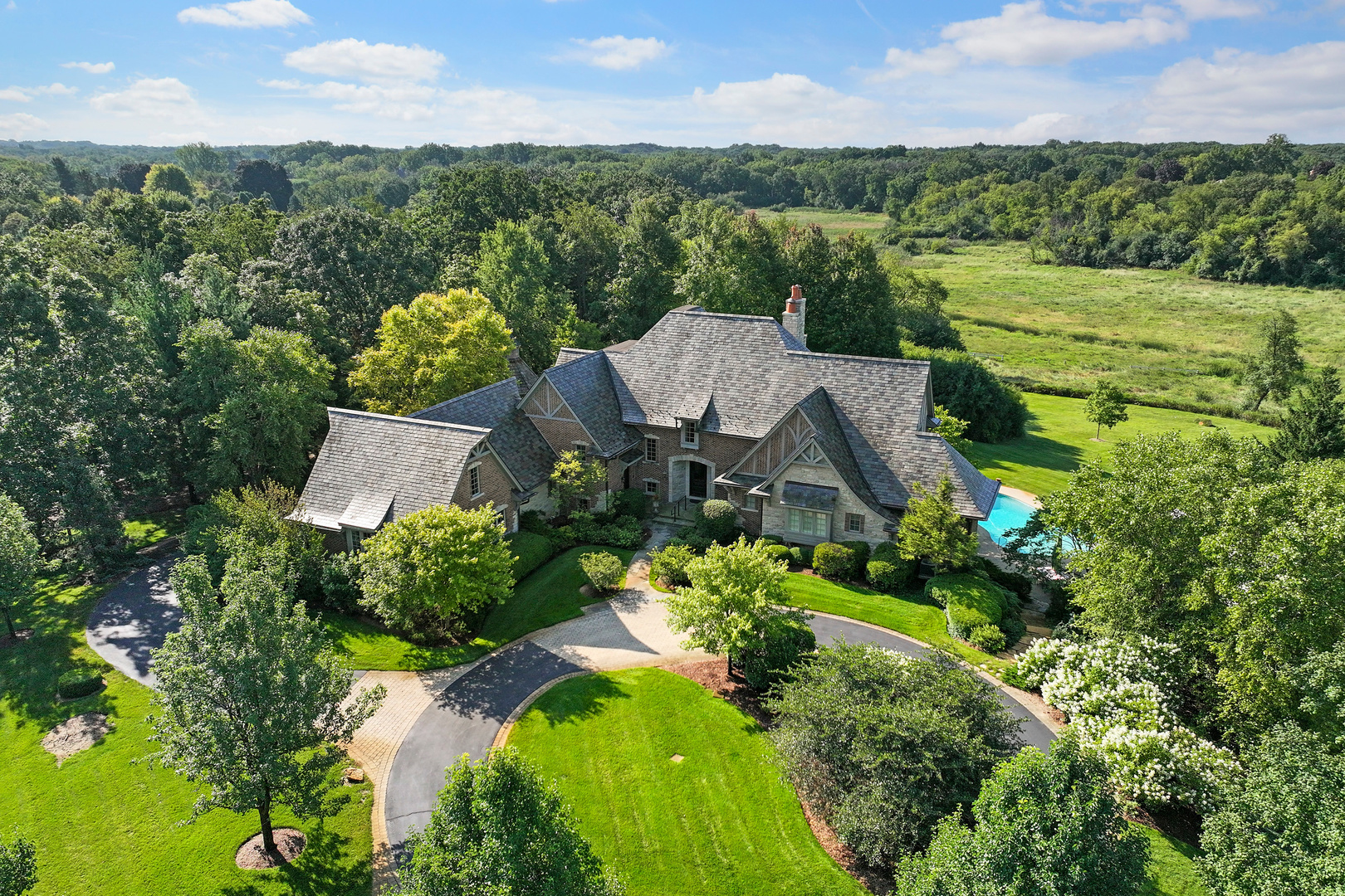 an aerial view of a house with a garden and lake view