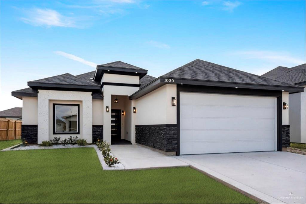 Prairie-style house featuring a front yard and a garage