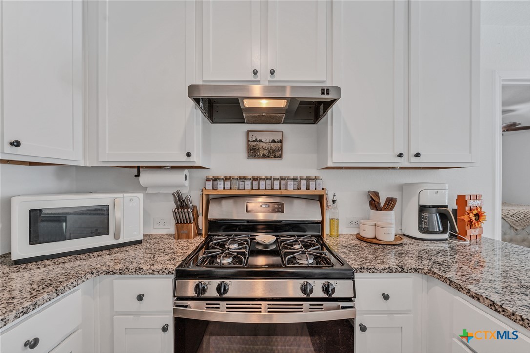 a stove top oven sitting inside of a kitchen