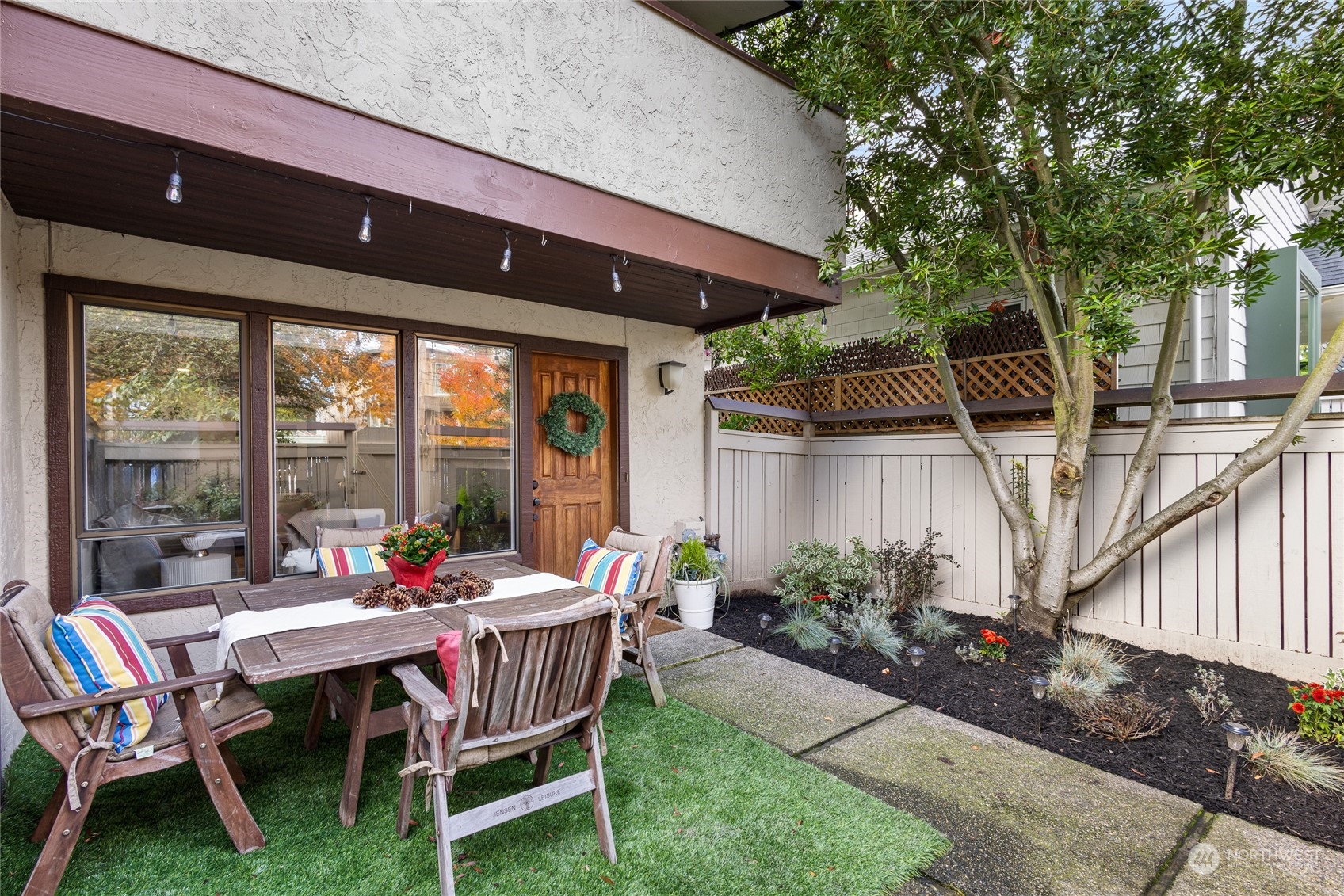 a patio with table and chairs and potted plants