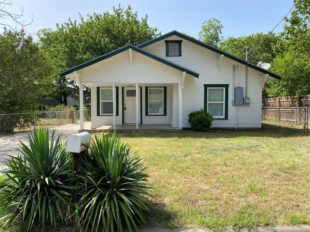 a front view of house with yard and trees around