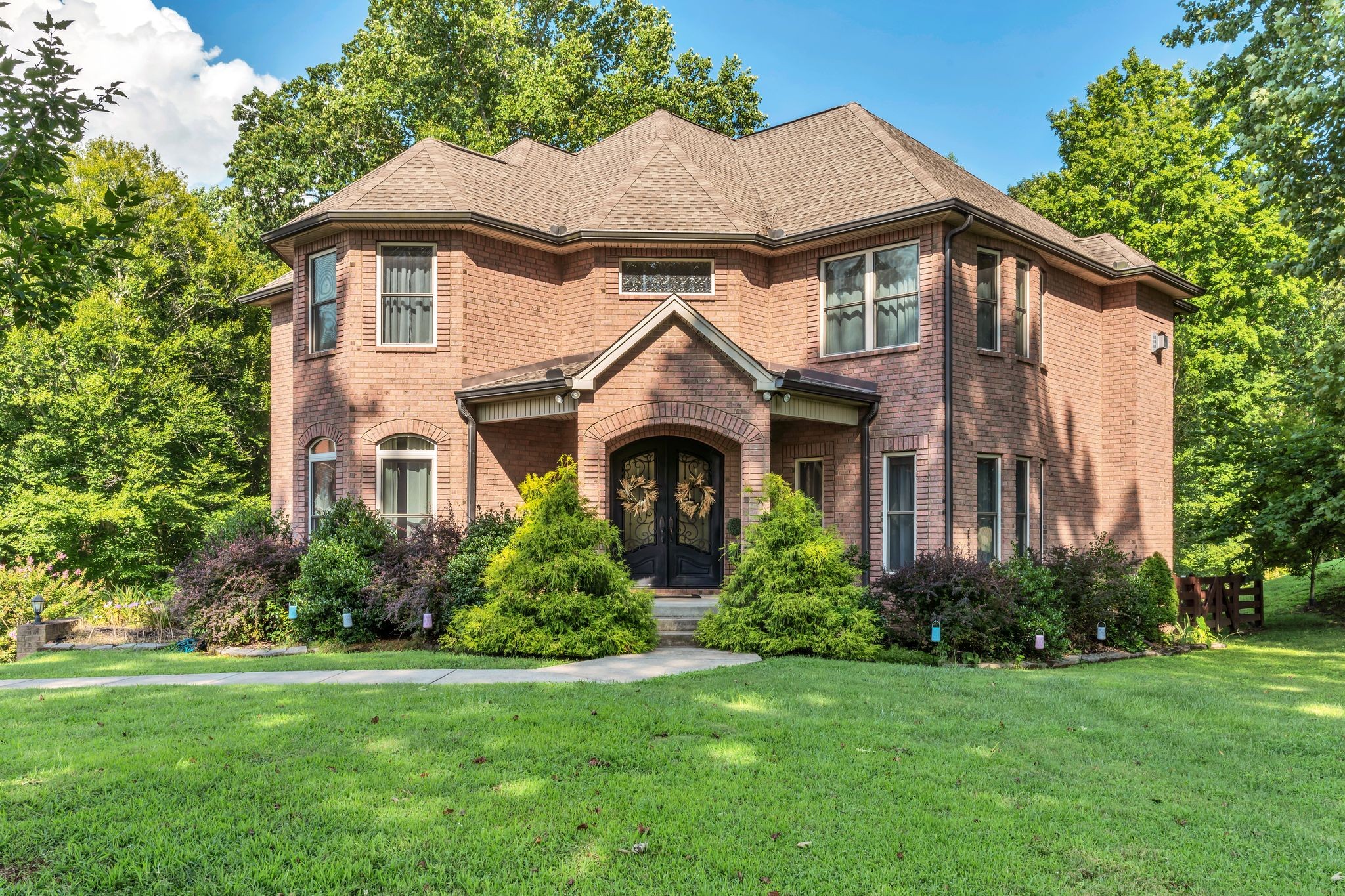 a front view of a house with a yard and trees