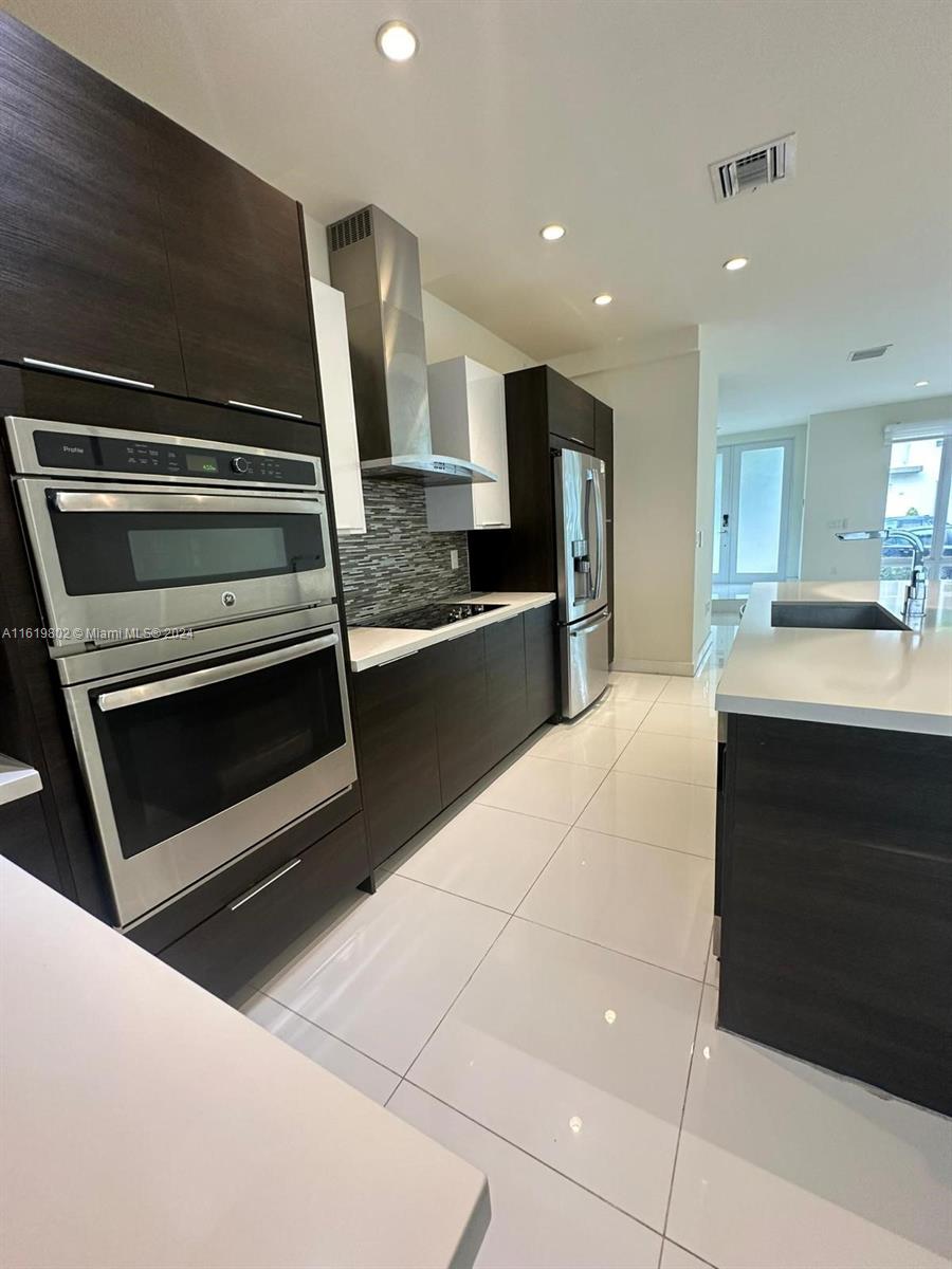 a kitchen with kitchen island granite countertop a stove and a sink