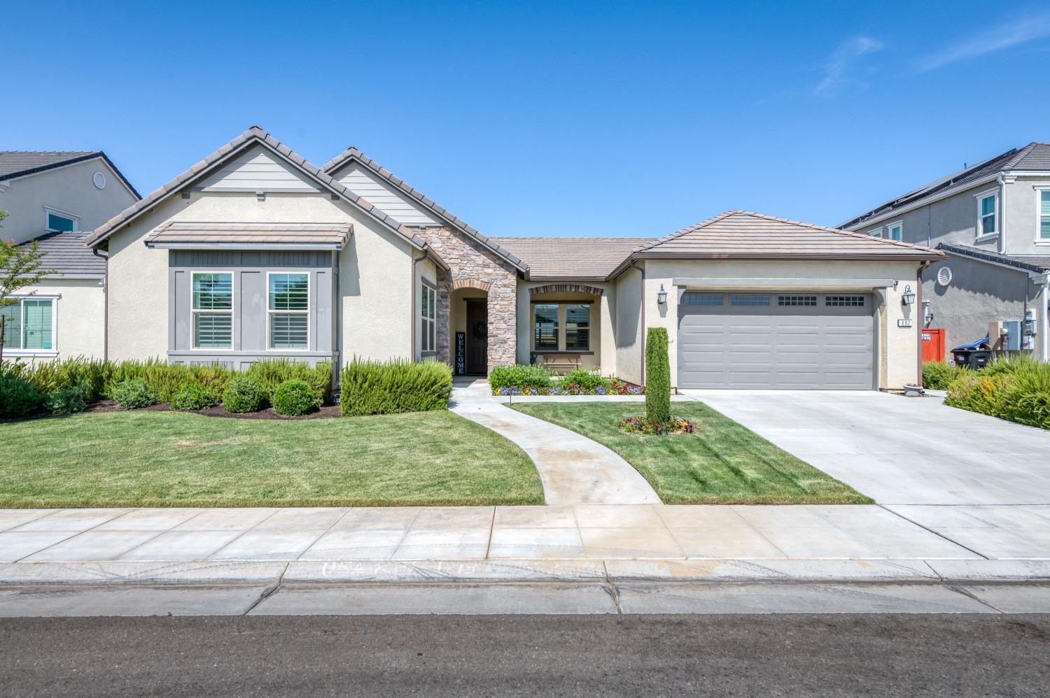 a front view of a house with a yard and garage