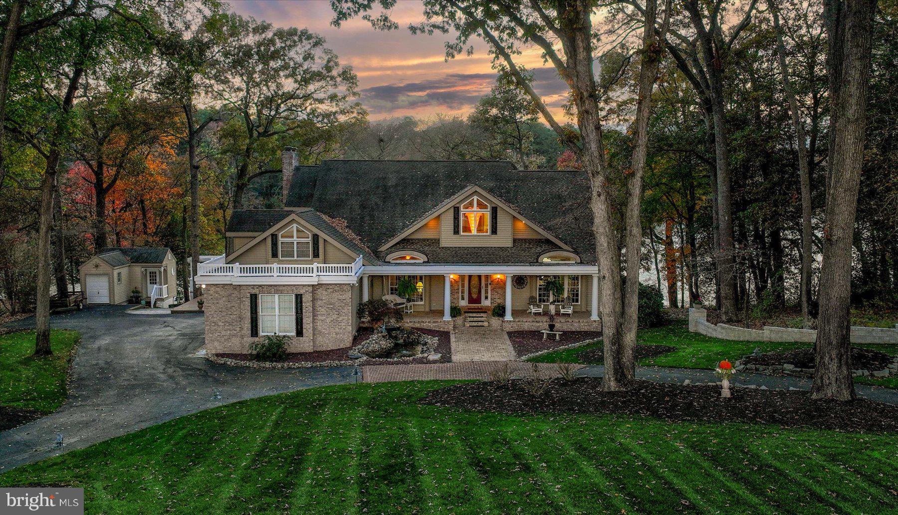 a front view of a house with a yard and green space