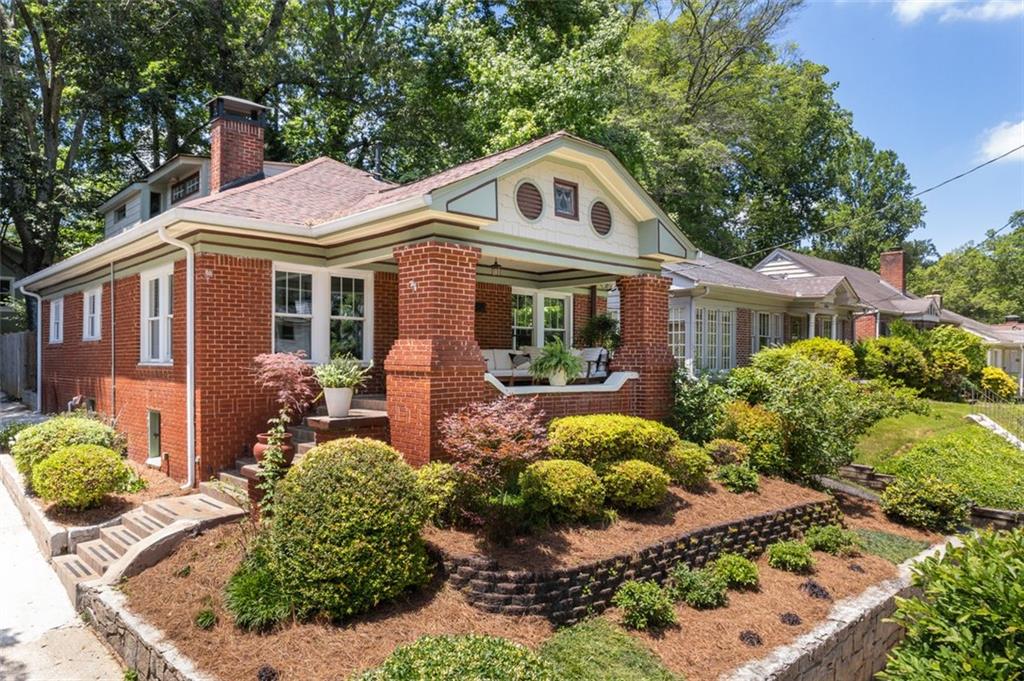 a front view of a house with a yard and potted plants