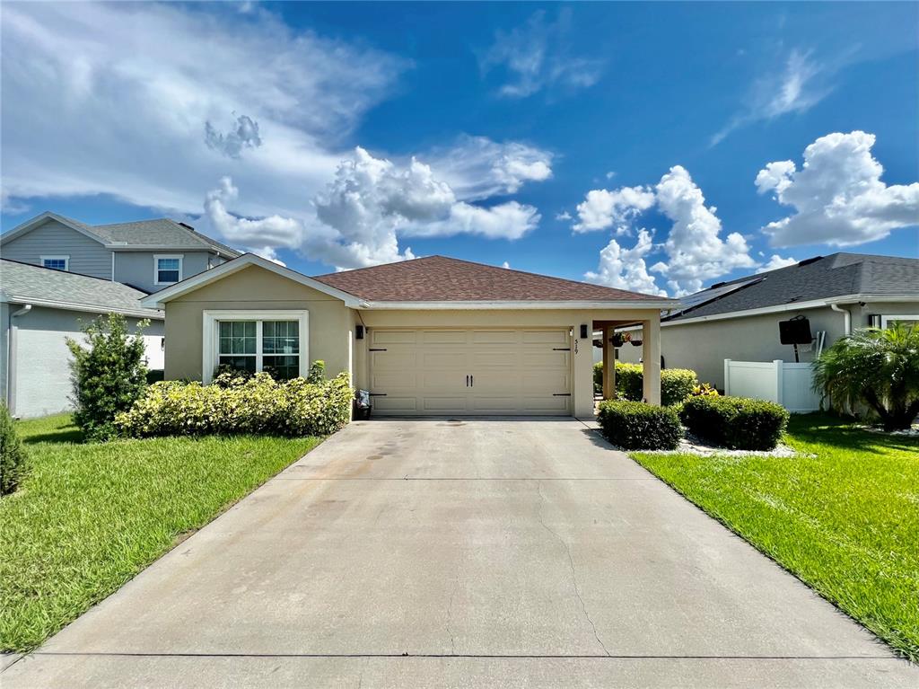 a front view of a house with a yard and a garage