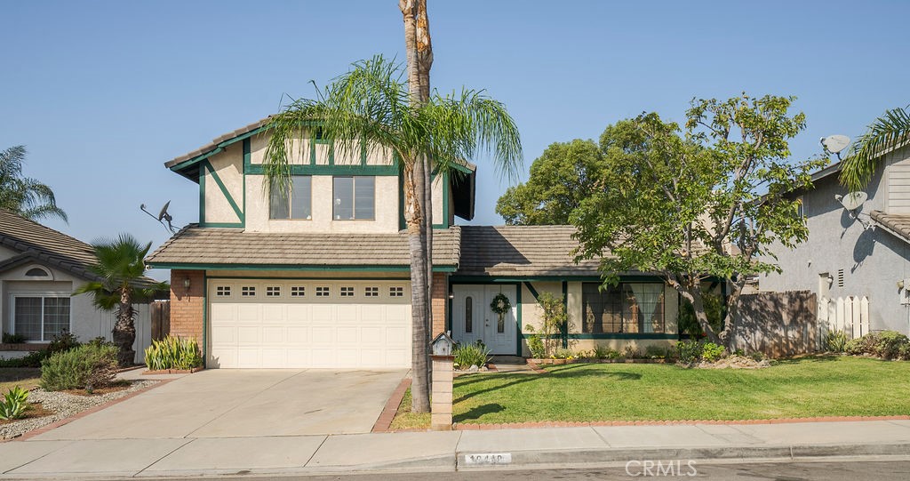 a front view of a house with a garden and plants