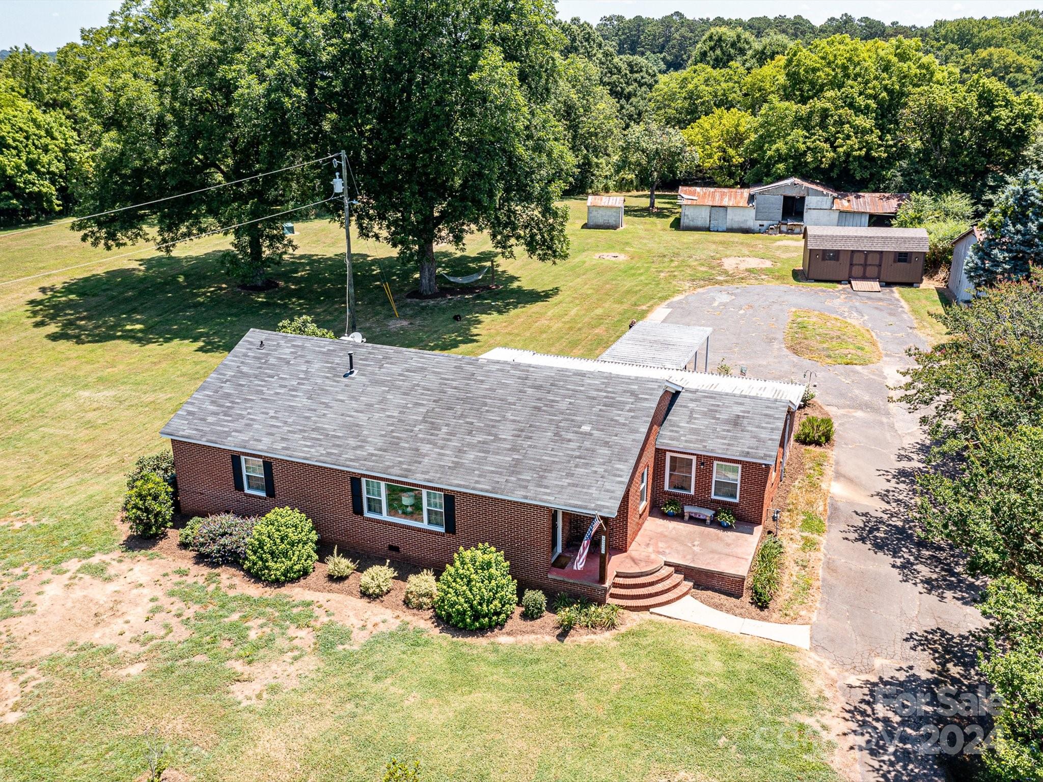 an aerial view of a house with swimming pool and a yard