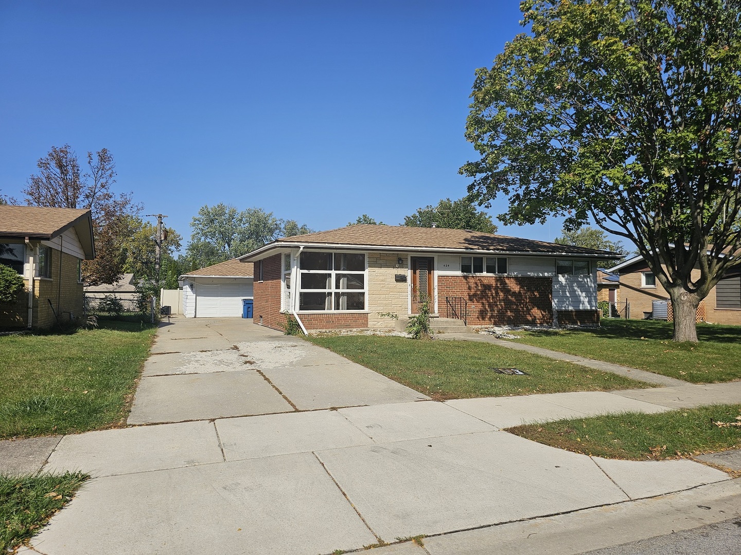 a front view of a house with a yard and trees