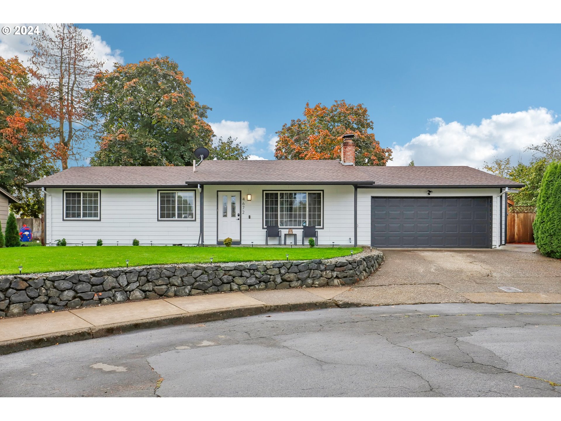 a front view of a house with a garden and garage