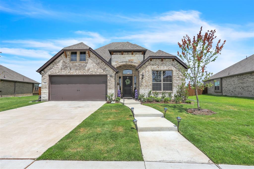 a front view of a house with a yard and garage