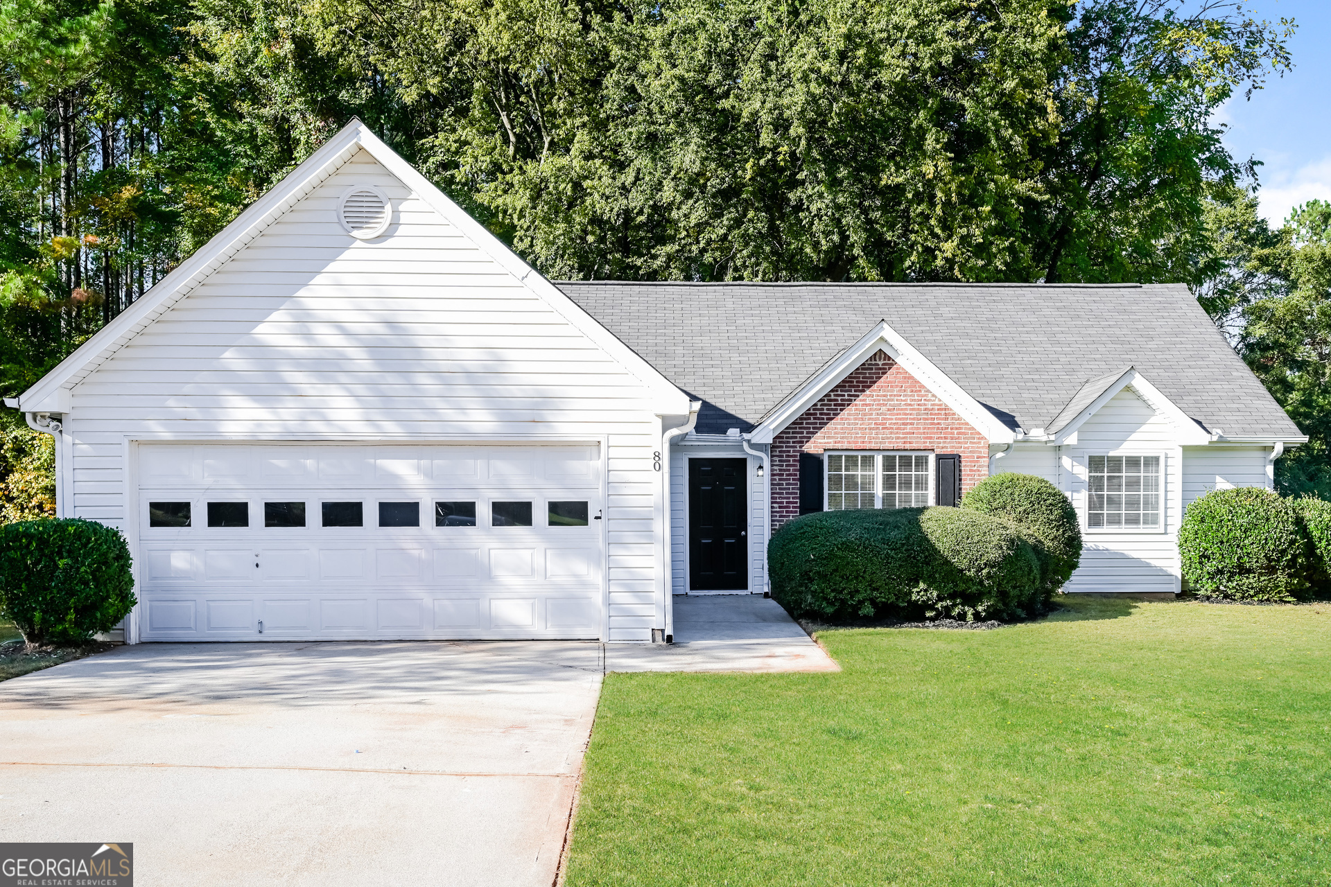 a view of house with yard and trees in the background