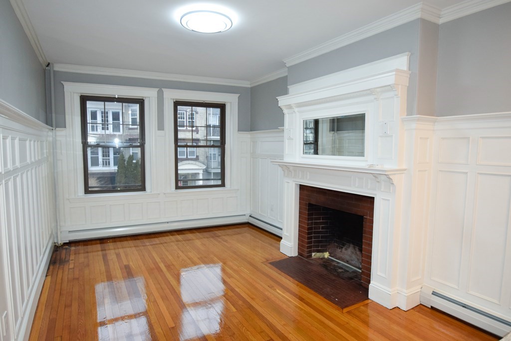 a living room with a fireplace and windows