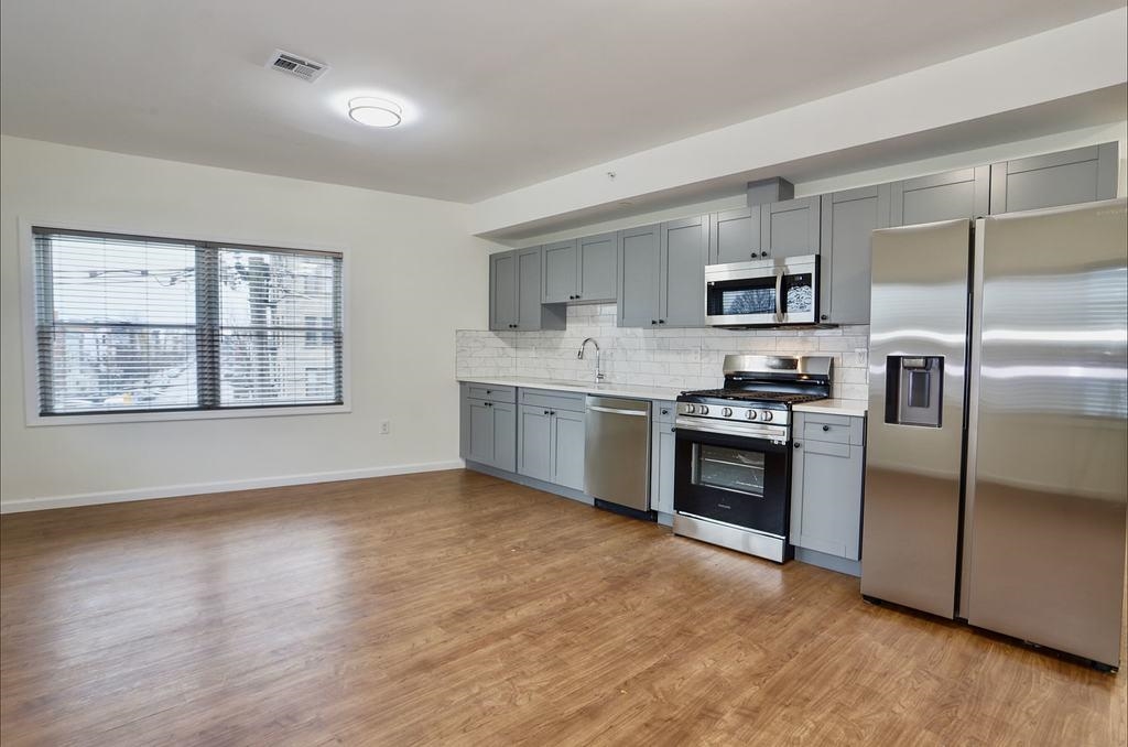 a kitchen with stainless steel appliances granite countertop a stove a sink and a refrigerator