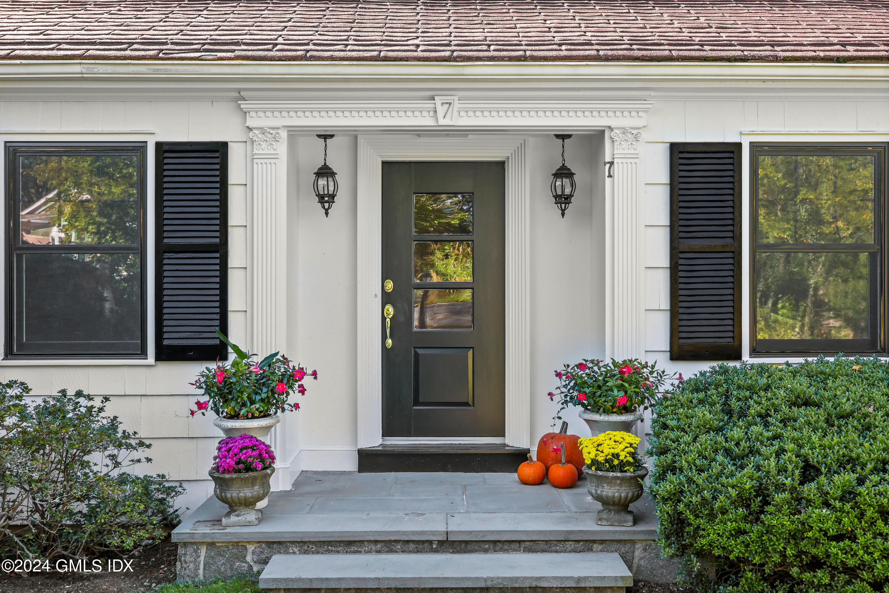 a flower garden in front of the house