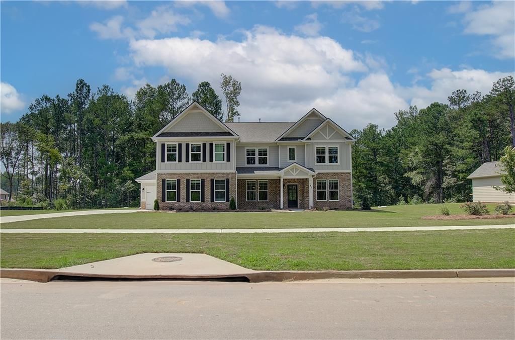 a front view of a house with a garden and trees