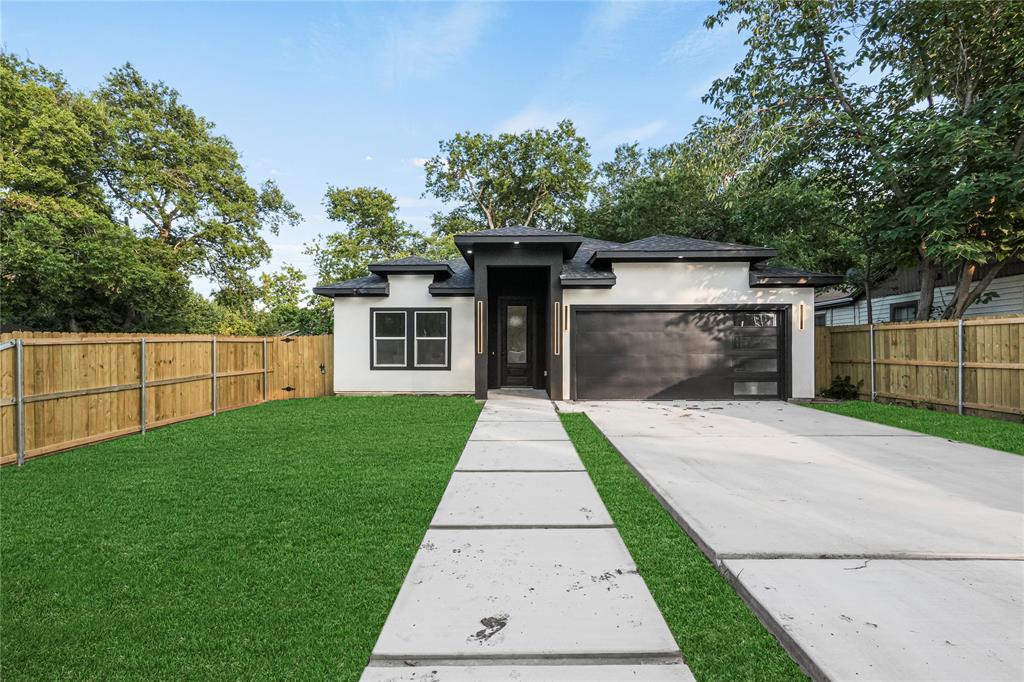 a front view of a house with a yard and a garage