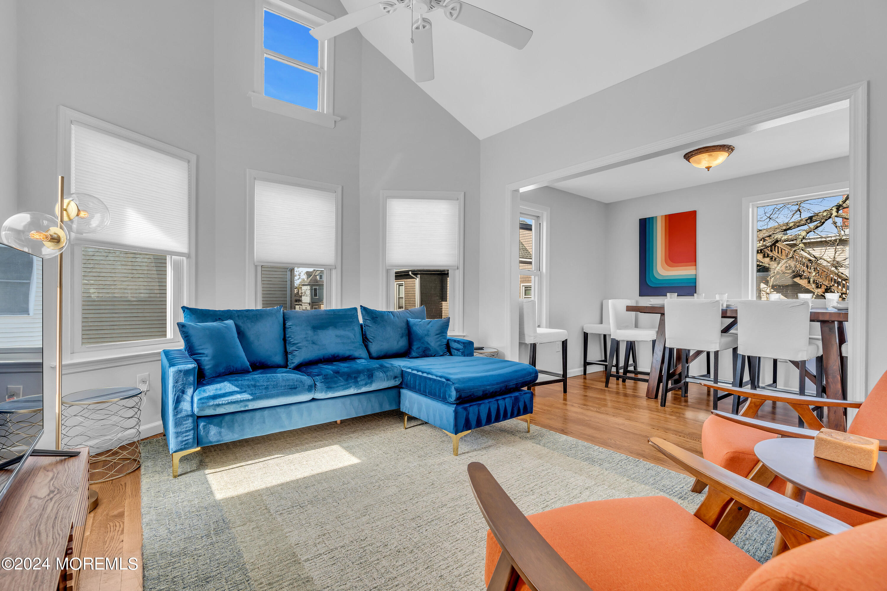 a living room with furniture kitchen view and a large window