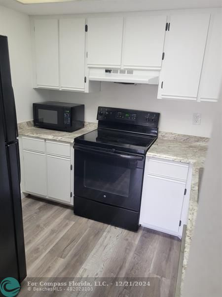 a kitchen with a stove and white cabinets