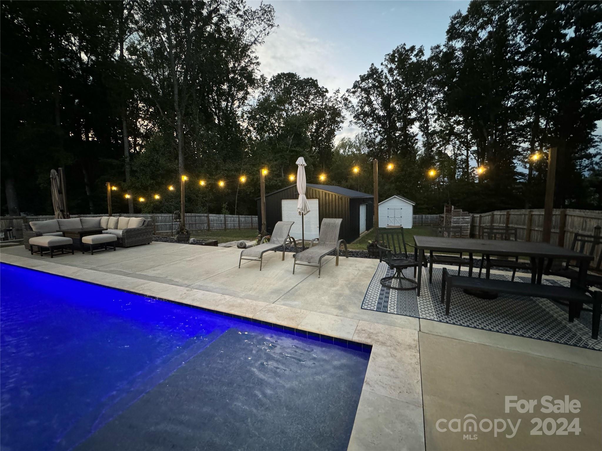 a view of swimming pool with outdoor seating and trees