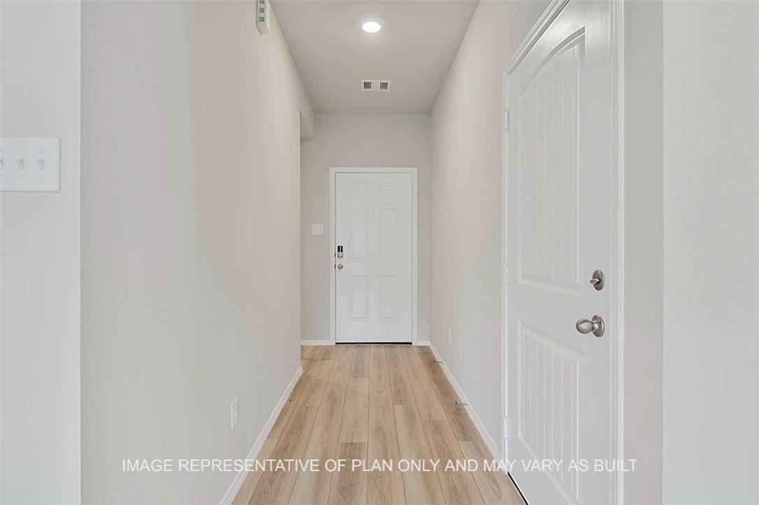 Hallway with light hardwood / wood-style flooring