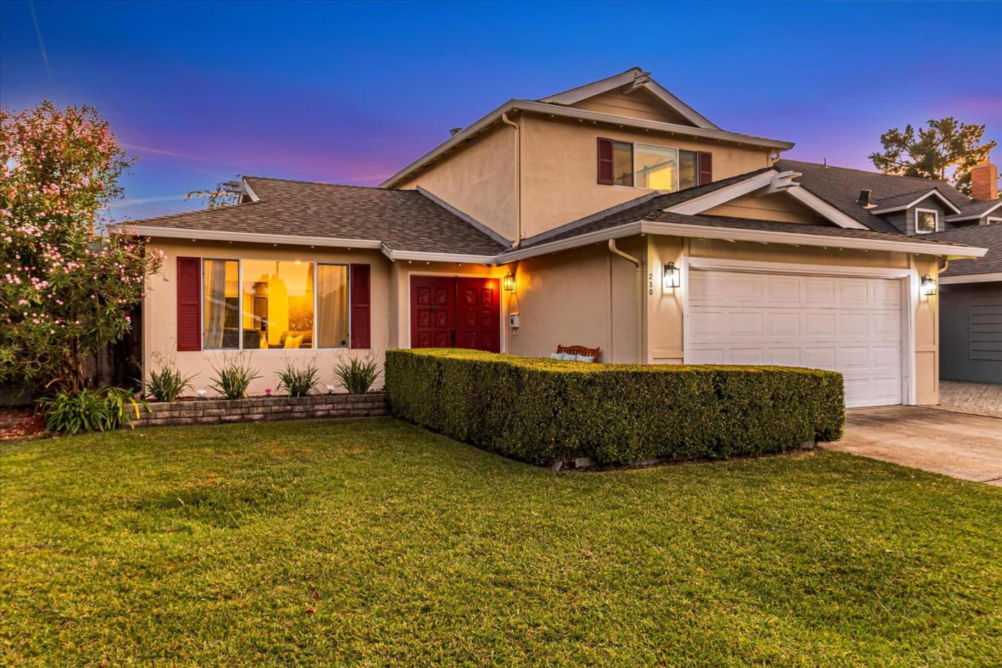 a front view of a house with a garden and yard